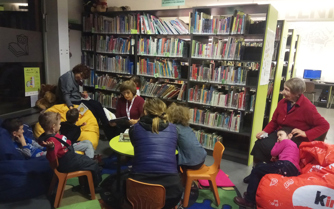 Wolontariuszka w bibliotece przy ul. Mickiewicza 65 czyta dzieciom bajki