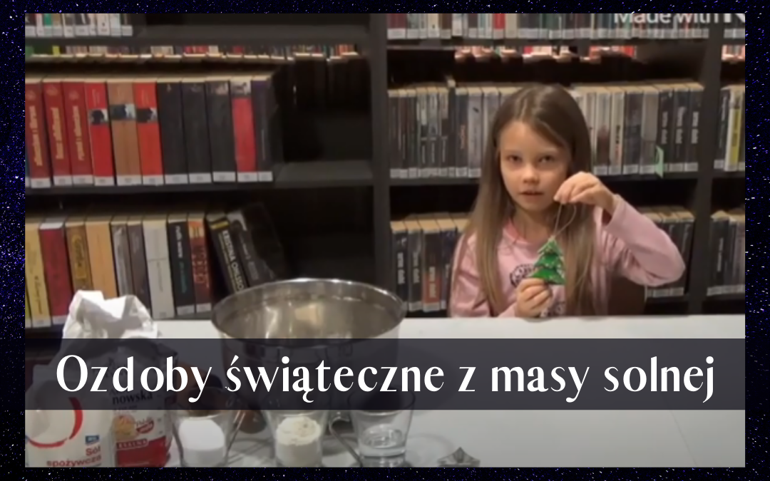 Kadr z filmu instruktażowego o ozdobach świątecznych z masy solnej. Na zdjęciu dziewczynka prezentuję ozdobę, którą następnie wykona podczas filmu