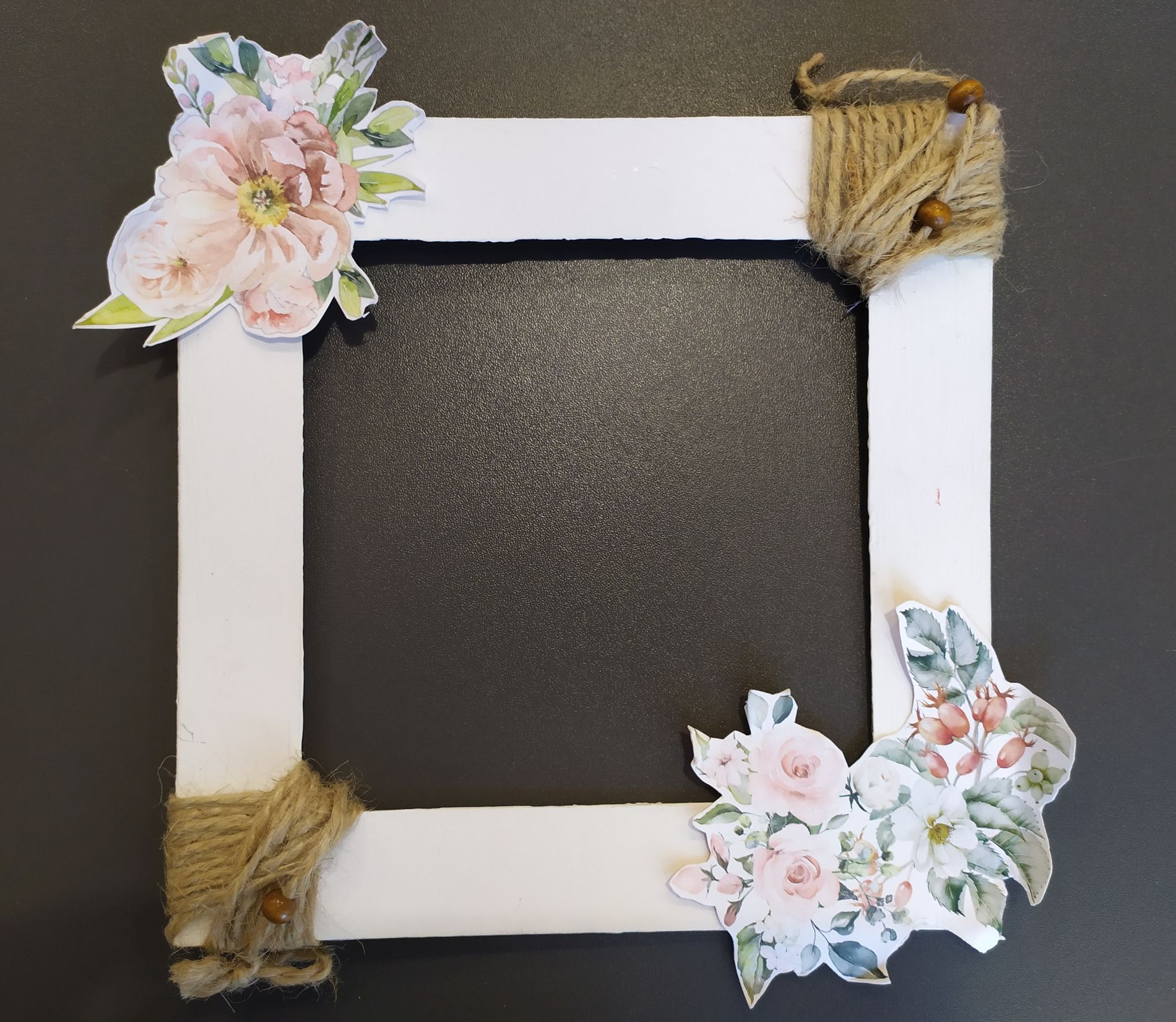 kartonowa ramka na zdjęcie pomalowana na biało i ozdobiona papierowymi kwiatami i sznurkiem