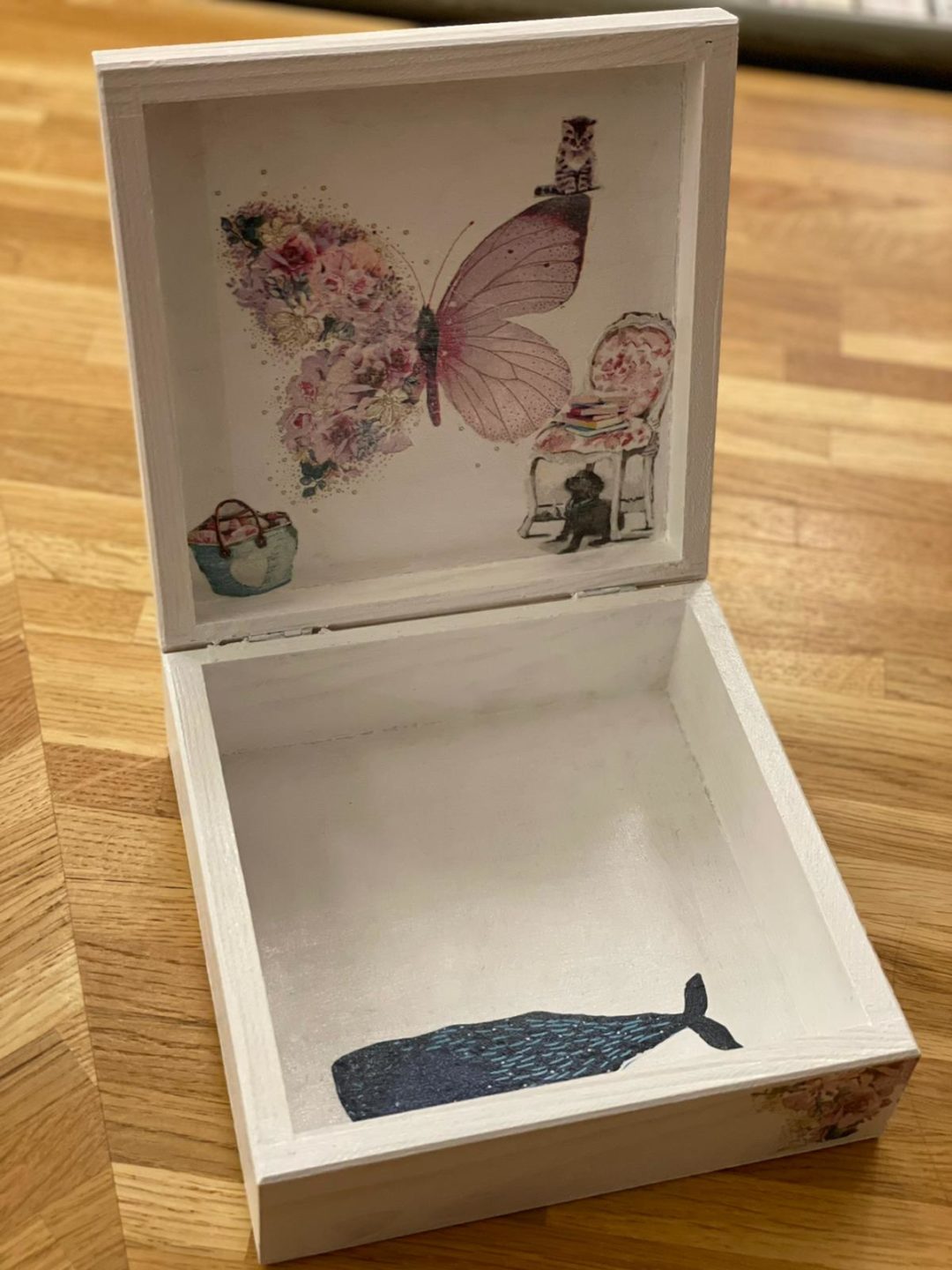 zdjęcie przedstawiające pudełko wykonane metodą decoupage w środku wzory z motylem i wielorybem