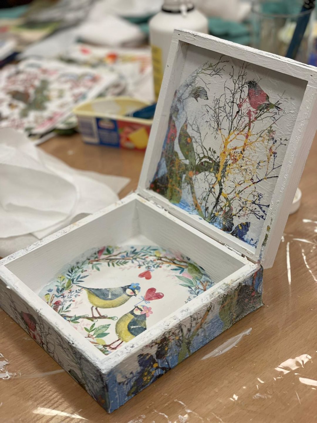zdjęcie przedstawiające pudełko wykonane metodą decoupage w środku wzory w kwiaty, gałęzie drzew i ptaki