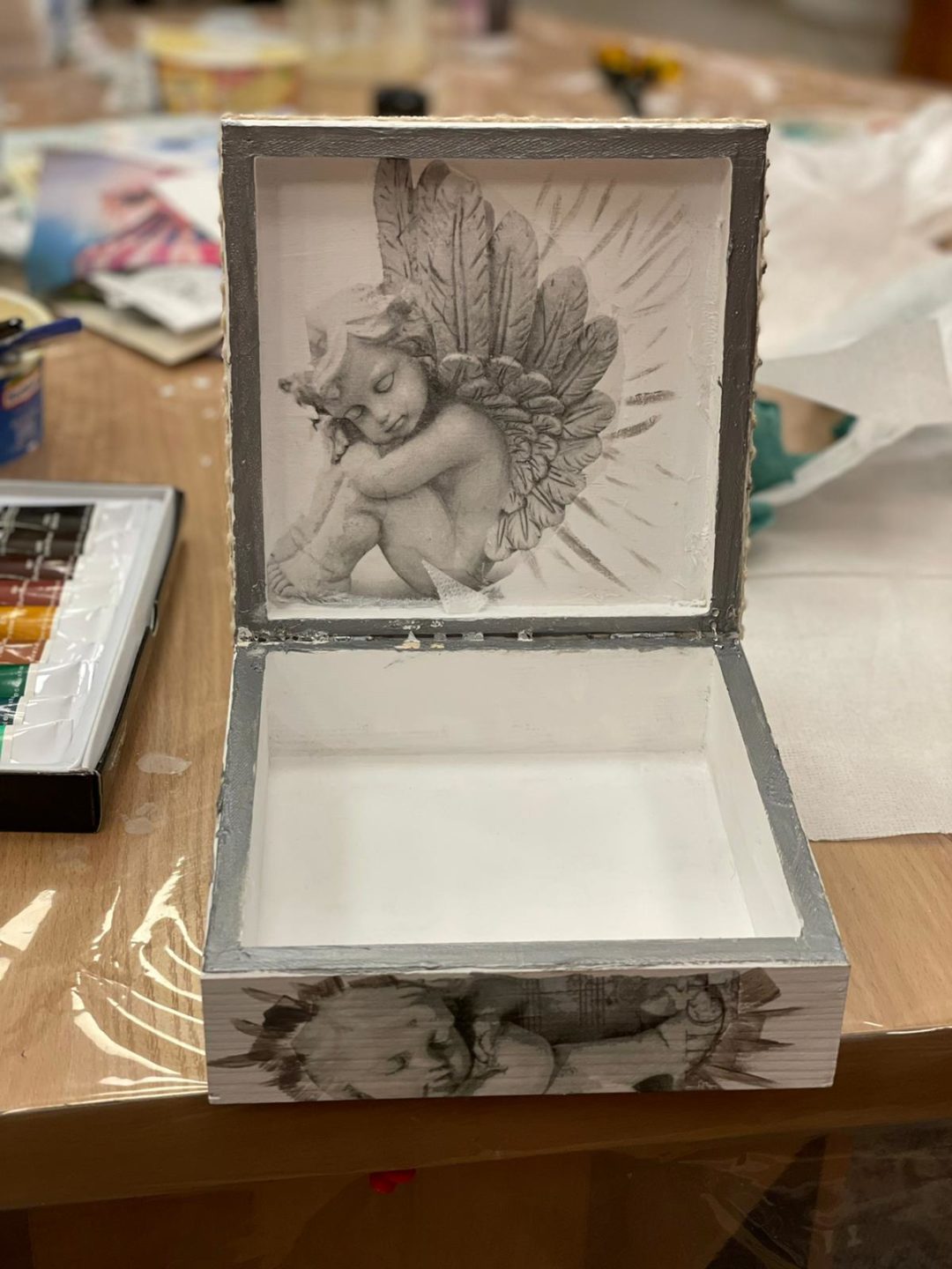 zdjęcie przedstawiające pudełko wykonane metodą decoupage w środku wzór z aniołem