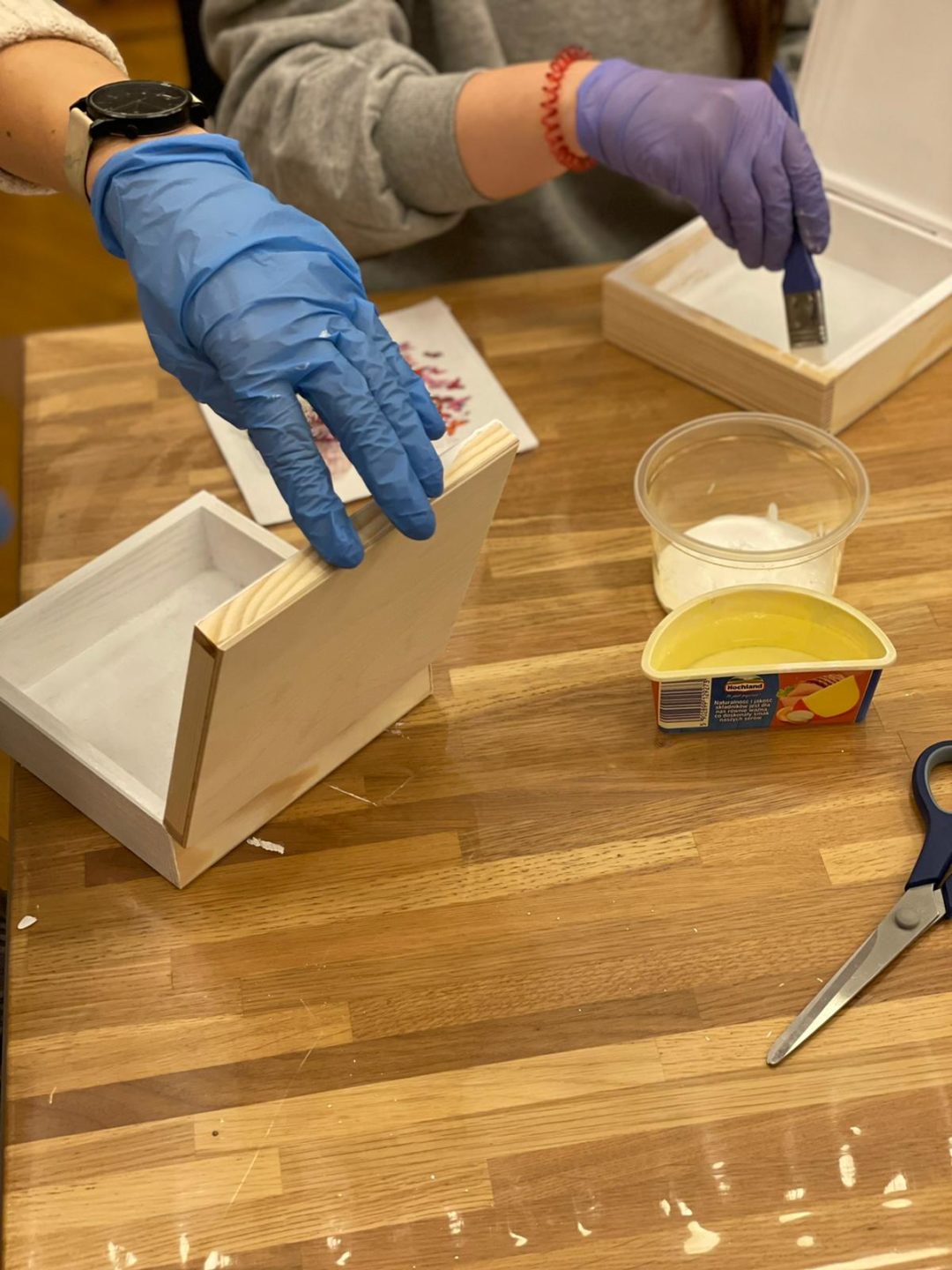 zdjęcie przedstawiające ozdabianie drewnianych pudełek metodą decoupage malowanie białą farbą akrylową