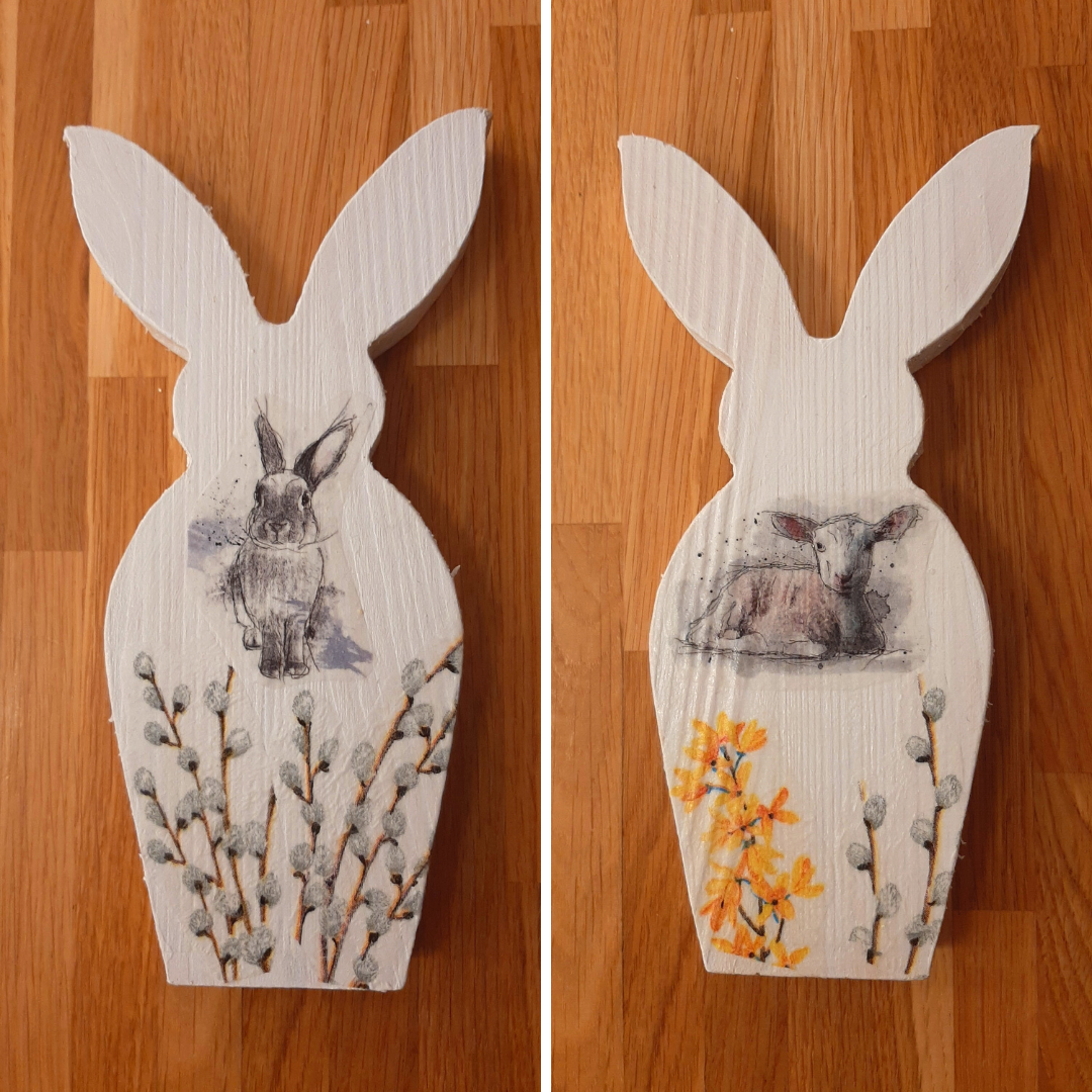 zdjęcie przedstawiające dwie formy drewniane w kształcie królików ozdobione metodą decoupage: zając z baziami oraz baranek z baziami