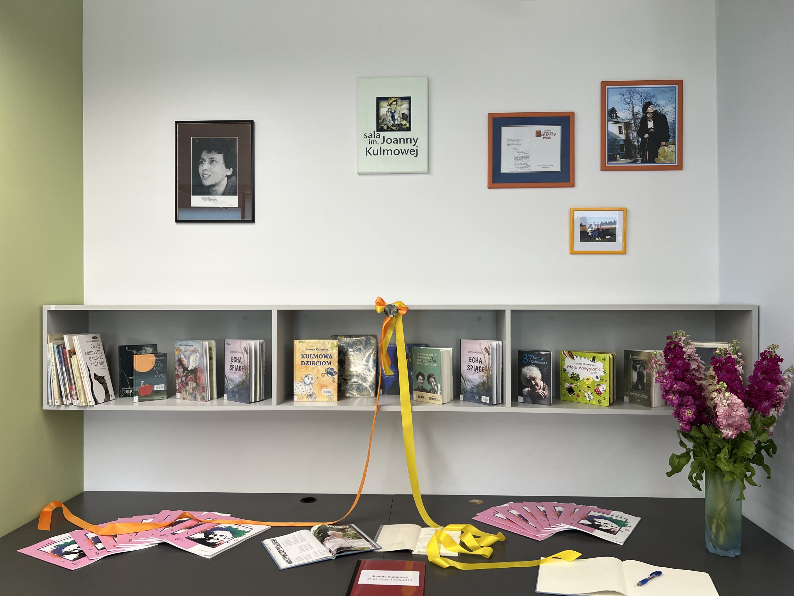 ściana poświęcona Joannie Kulmowej, na ścianie wiszą zdjęcia poetki, niżej ustawione są jej książki
