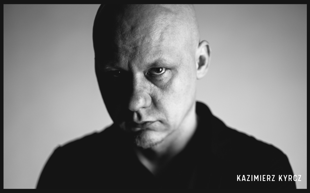 Czarno białe zdjęcie autora, Kazimierza Kyrcza Jr z białym podpisem Kazimierz Kyrcz