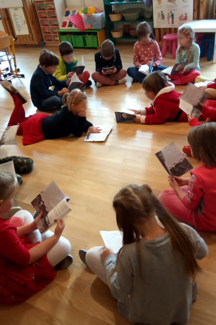 zdjecie przedstawiające lekcję biblioteczną prowadzoną przez bibliotekarzy i wolontariusza w przedszkolu 131 w ramach partnerstwa przedszkola i biblioteki