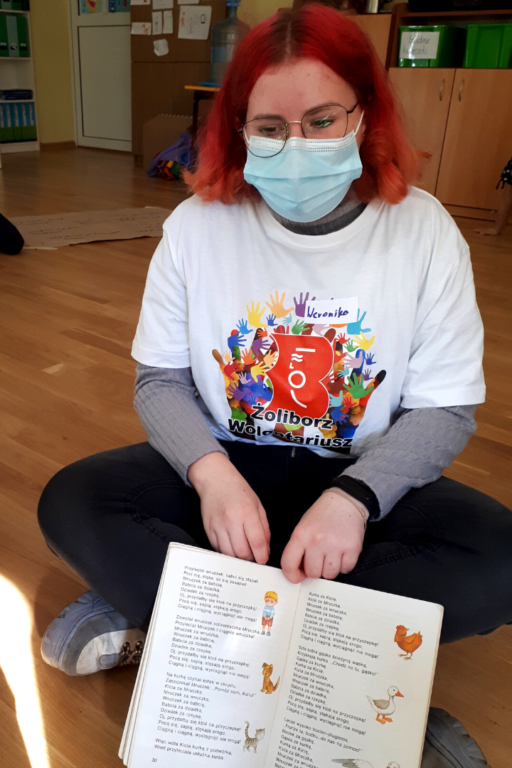 zdjecie przedstawiające lekcję biblioteczną prowadzoną przez bibliotekarzy i wolontariusza w przedszkolu 131 w ramach partnerstwa przedszkola i biblioteki