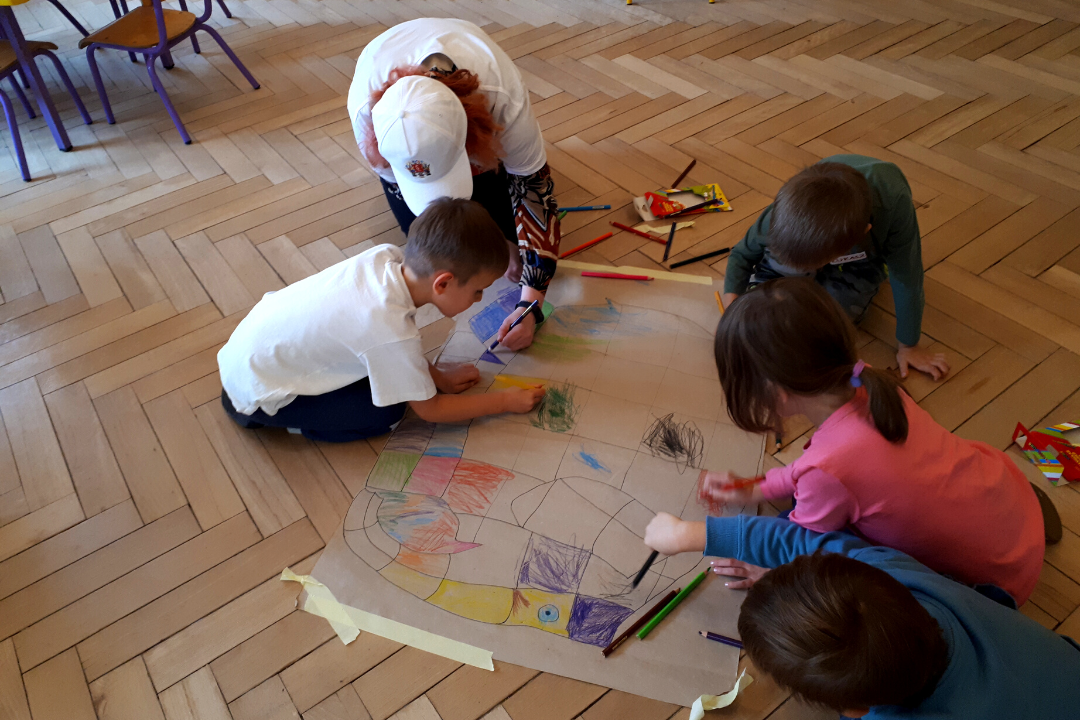zdjecie przedstawiające lekcję biblioteczną prowadzoną przez bibliotekarzy i wolontariusza w przedszkolu 131 w ramach partnerstwa przedszkola i biblioteki