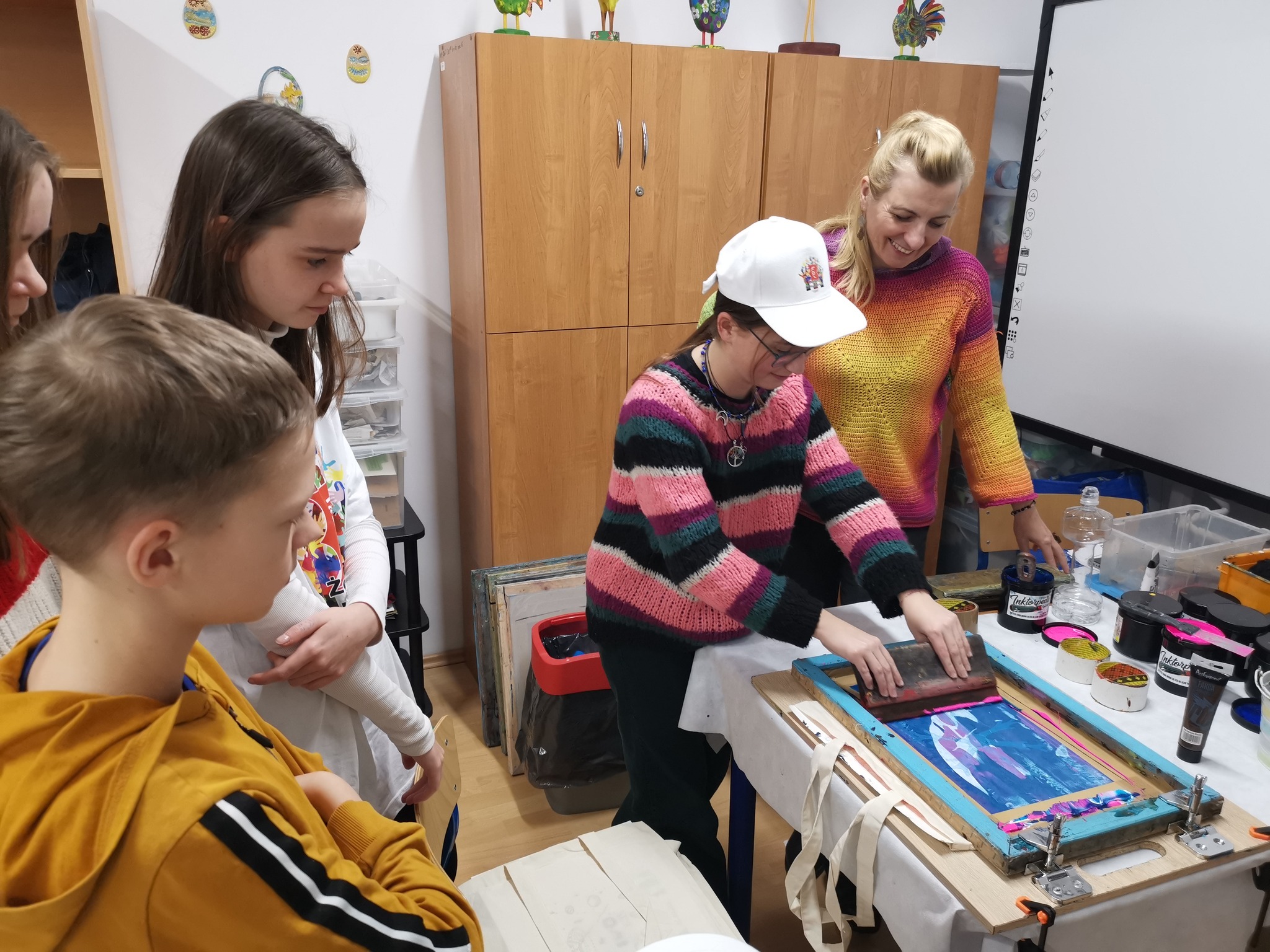 grafika wyróżniająca przedstawiająca uczestników warsztatów artystycznych w trakcie trwania zajęć