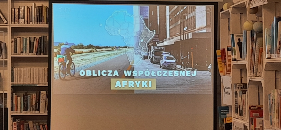 Fotografia przedstawia miasto afrykańskiego, w tle grafika przedstawiająca zarys kontynentu afrykańskiego.