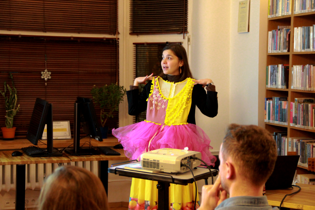 zdjęcie przedstawia podróżniczkę Katarzynę Maź podczas prezentacji stroju na spotkaniu podróżniczym o Maderze we wnętrzu Wypożyczalni nr 16