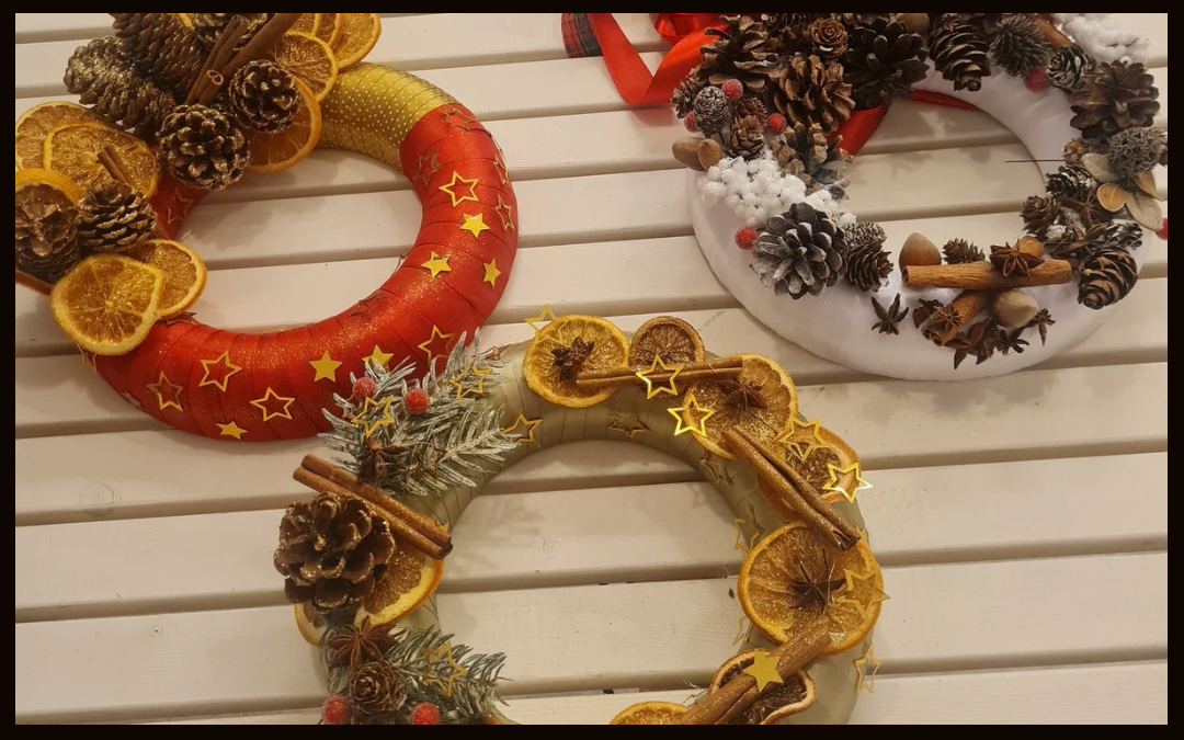 wieńce bożonarodzeniowe w kolorze czerwonym, białym i złotym, ozdobione szyszkami, cynamonem i suszonymi pomarańczami