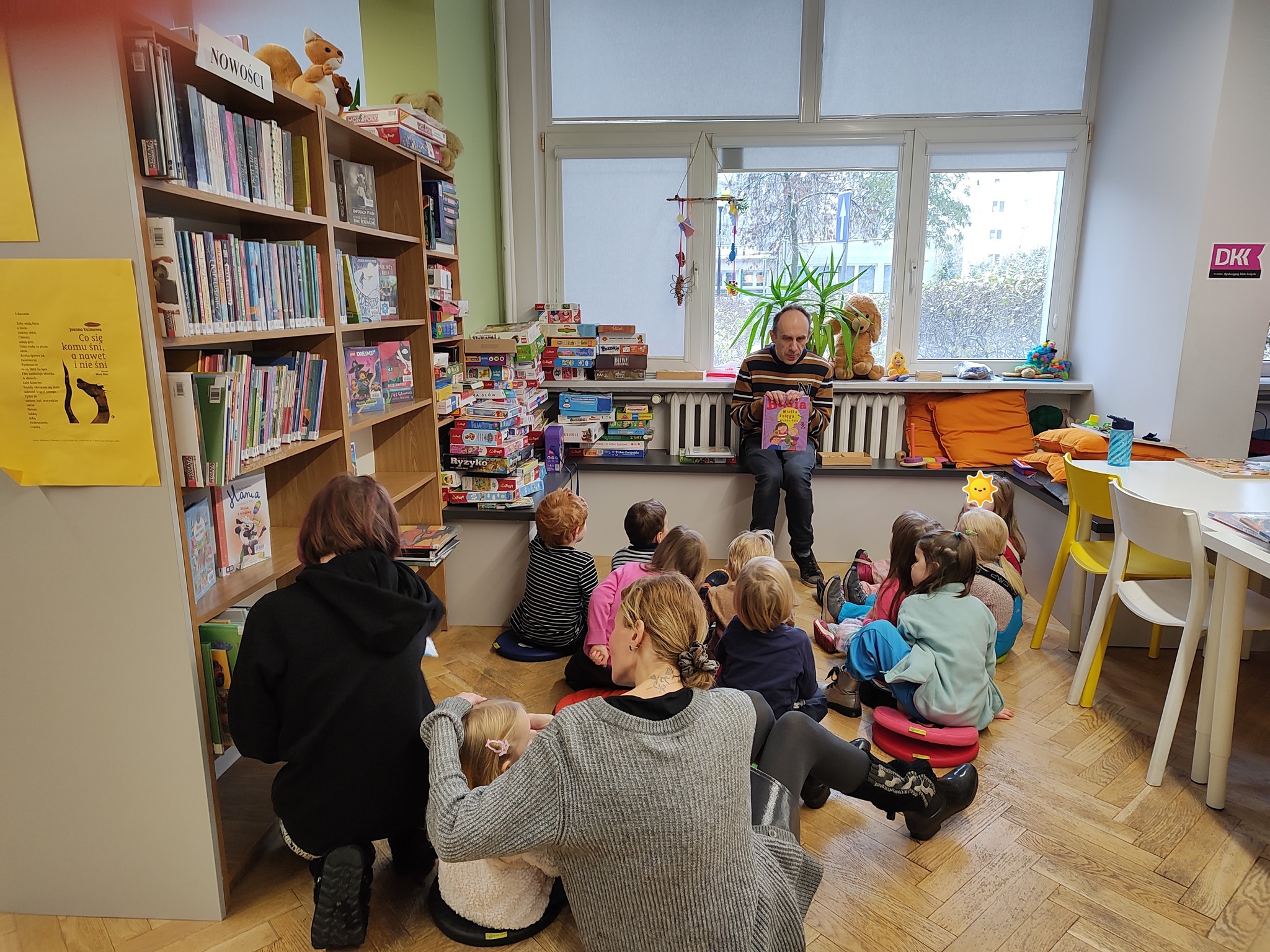 grafika wyróżniająca przedstawiająca grupę dzieci podczas rozmowy z bibliotekarzem o przeczytanej książce .