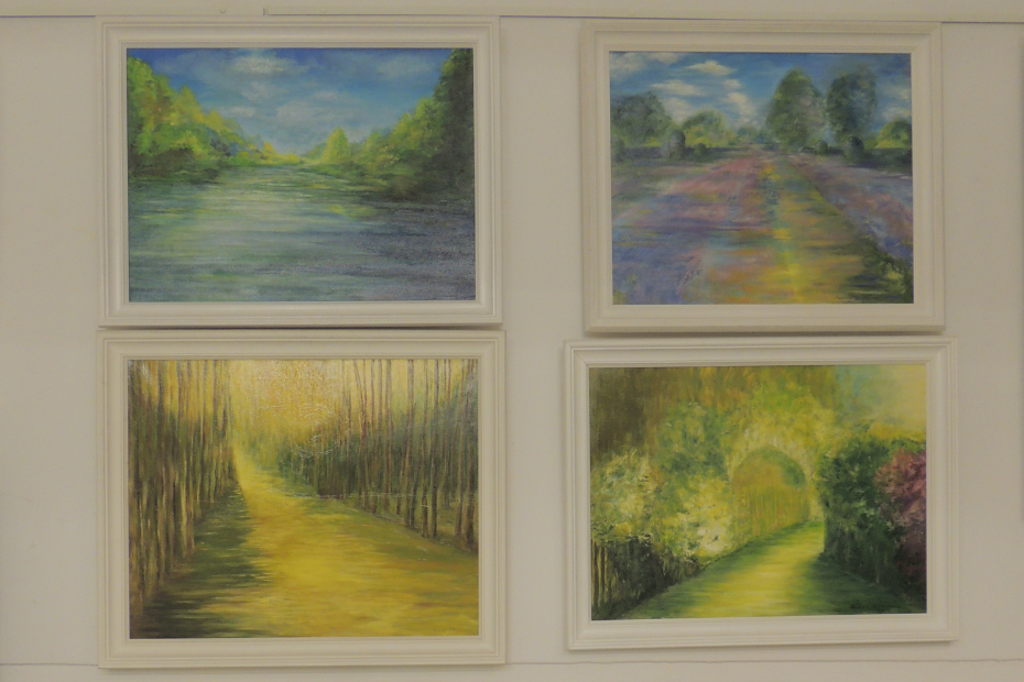 Zdjęcie przedstawia cztery obrazy olejne wiszące na ścienie w dwóch rzędach jeden nad drugim. Obrazy przedstawiają pejzaże z rzeką, polami, lasem i ogrodem.
