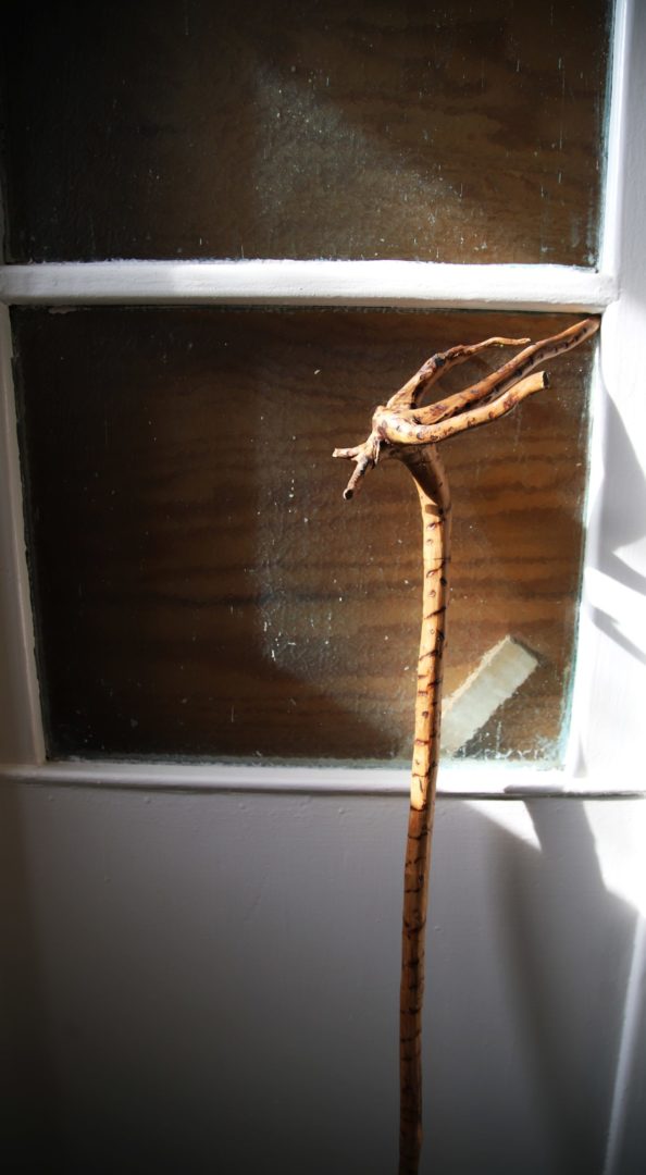 zdjęcie z wnętrza Muzeum Książki Dziecięcej lub inaczej Izby Pamięci Marii Kownackiej, która mieści się na warszawskim Żoliborzu przy ulicy Słowackiego 5/13 m. 74. zdjęcie drewnianej laski opartej o framugę okna.