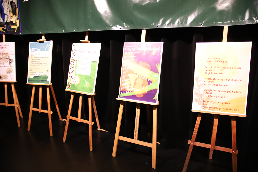 Zdjęcie z II Żoliborskiego Konkursu Recytatorskiego im. Joanny Kulmowej zorganizowanego przez Bibliotekę Publiczną w Dzielnicy Żoliborz, Społeczny Dom Kultury WSM oraz Fundację Joanny i Jana Kulmów. sztalugi z poezją Joanny Kulmowej postawione na scenie sali Społecznego Domu Kultury.