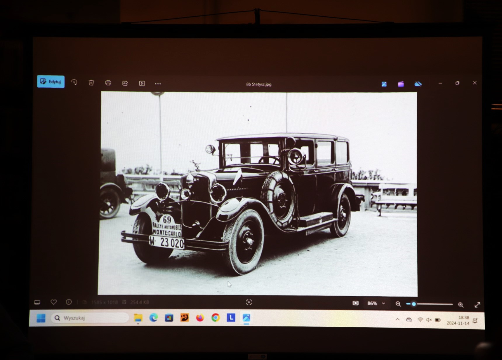 Zdjęcie z prelekcji "Motoryzacja Polska w Dwudziestoleciu Międzywojennym" we wnętrzu Wypożyczalni nr 16. Slajd z rzutnika z przedwojenną fotografią samochodu Stetysz.