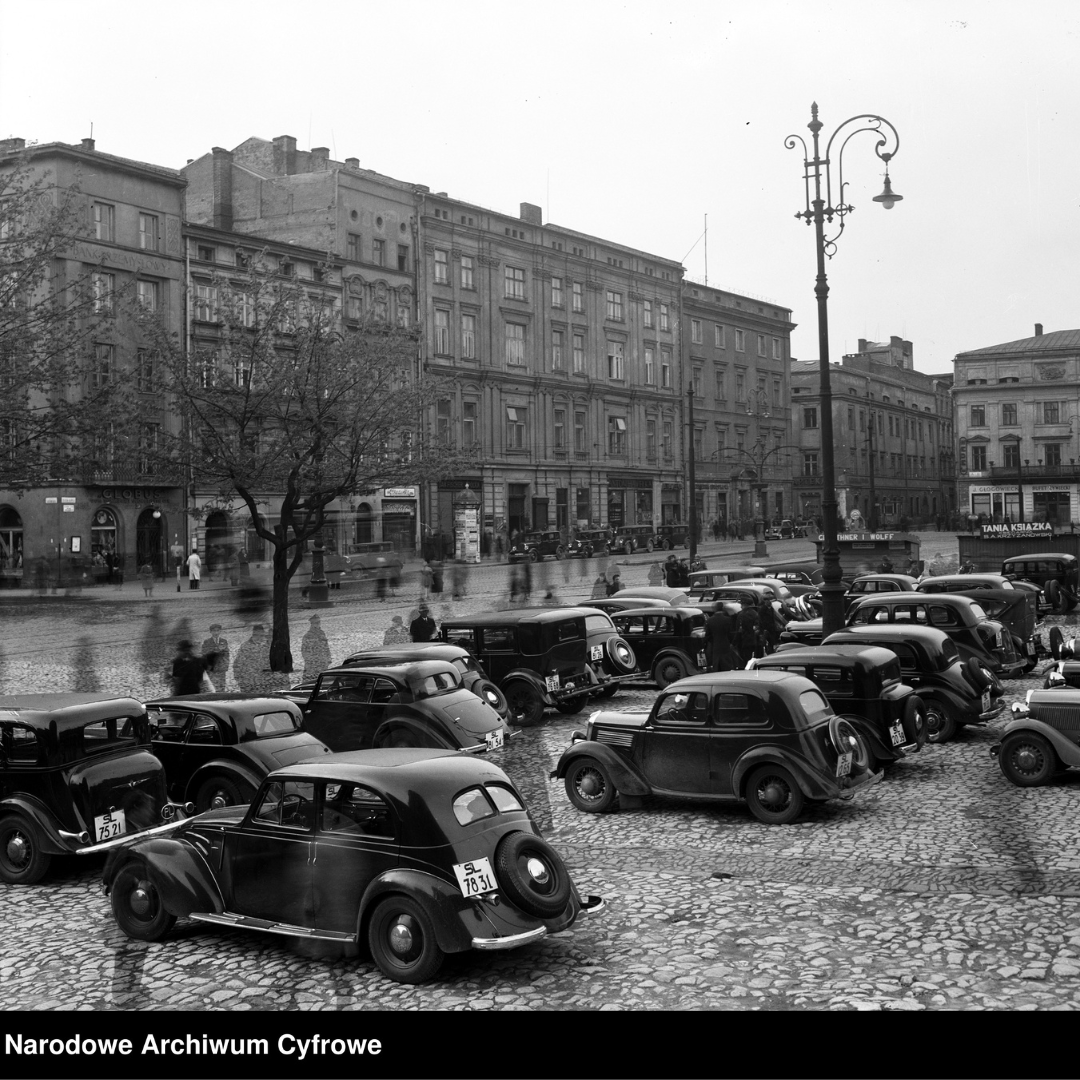 Fotografia z lat 1930-1939, autor zdjęcia nieznany, Rynek Główny w Krakowie. Fragment linii C-D i A-B. Widoczne samochody osobowe na rynku na tle budynków staromiejskich. Napis w dolnym lewym rogu: Narodowe Archiwum Cyfrowe.