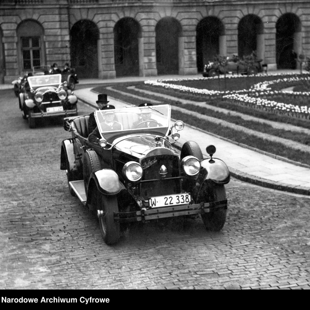 Fotografia z lat 1930-1939, autor zdjęcia nieznany, Wybór prezydenta RP przez Zgromadzenie Narodowe. Premier Aleksander Prystor, marszałek sejmu Wacław Makowski i marszałek senatu Władysław Raczkiewicz wyjeżdżają samochodami Packard spod gmachu Rady Ministrów w celu powiadomienia Ignacego Mościckiego o ponownym wyborze na prezydenta RP. Napis w dolnym lewym rogu: Narodowe Archiwum Cyfrowe.