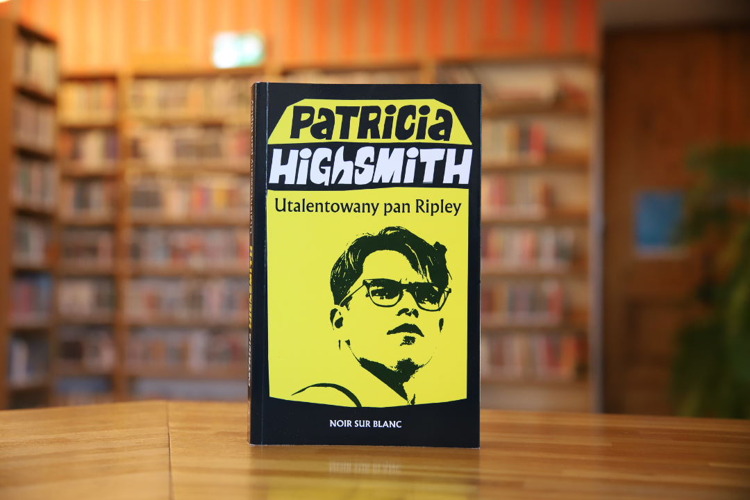 zdjecie przedstawia okładkę książki utalentowany pan ripley patricii highsmith na tle wnętrza wypożyczalni nr 16, widoczne napisy: patricia highsmith utalentowany pan ripley, noir sur blanc