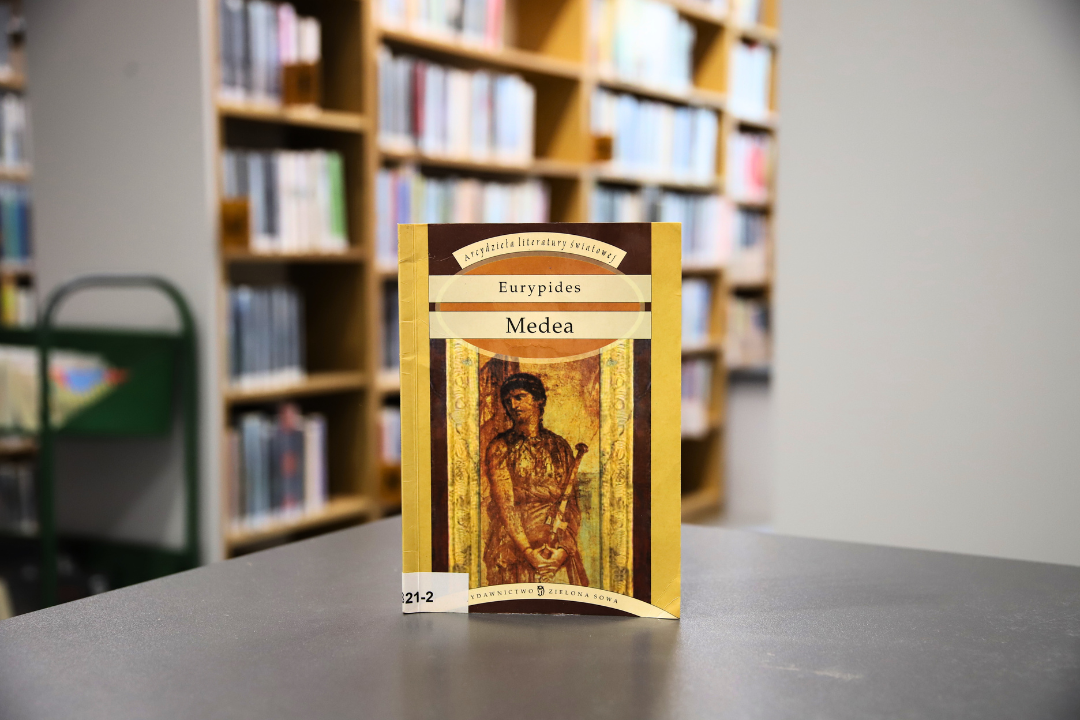 zdjecie przedstawia okładkę książki medea eurypidesa na tle wnętrza wypożyczalni nr 138, widoczne napisy: arcydzieła literatury światowej Eurypides medea wydawnictwo zielona sowa