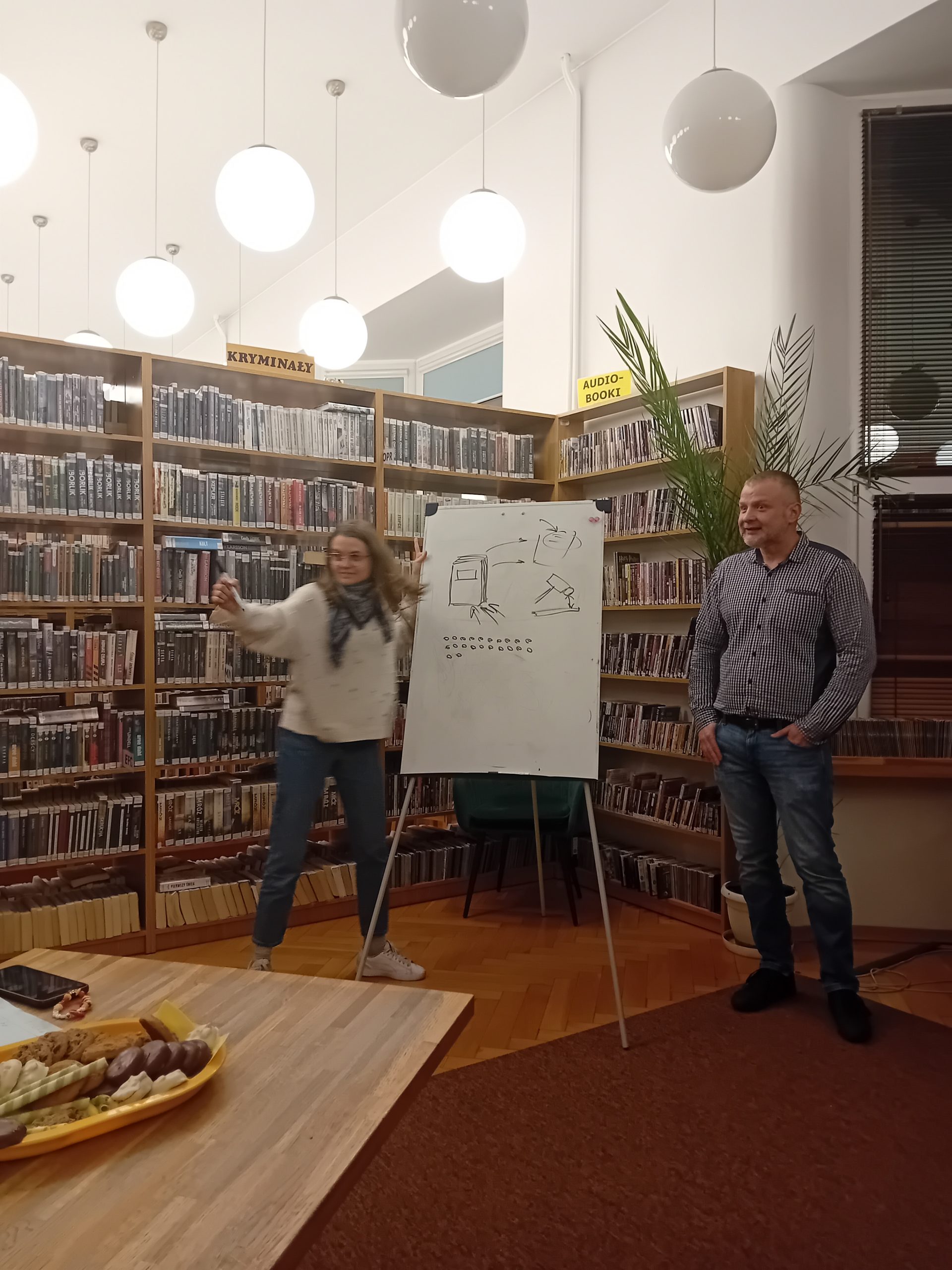 grafika wyróżniająca przedstawiająca jedną z uczestniczek i prowadzącego kalambury literackie