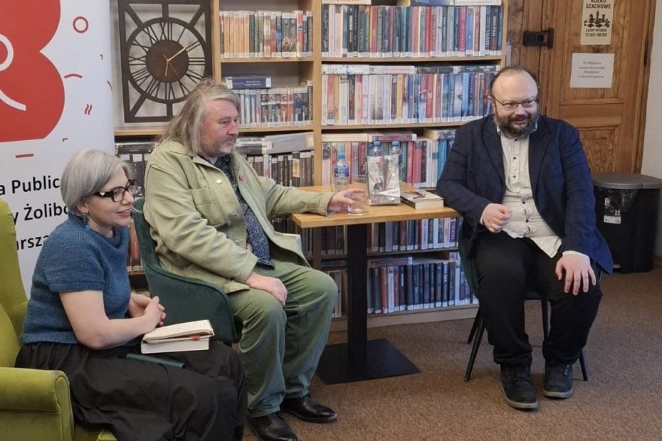 fotografia gości spotkania autorskiego we wnętrzu biblioteki